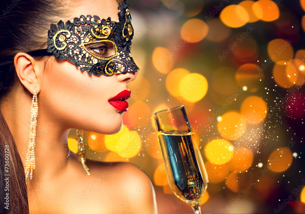 Sexy model woman wearing carnival mask with glass of champagne