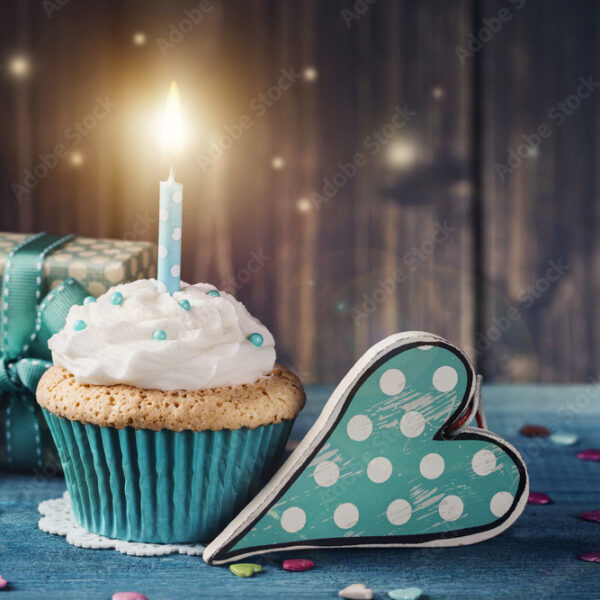Cupcake with birthday candle and gift box
