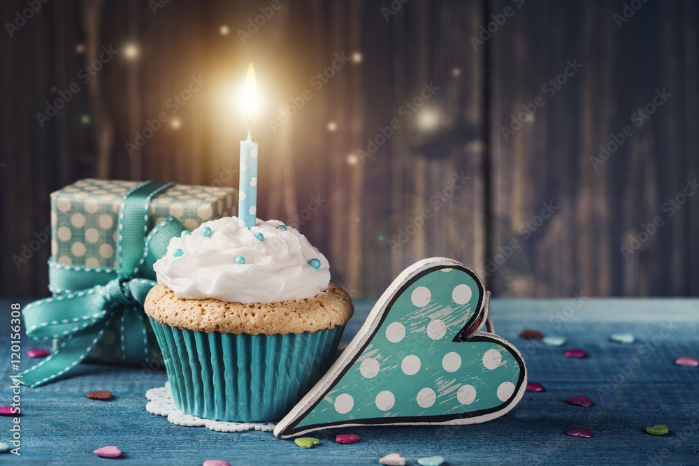Cupcake with birthday candle and gift box
