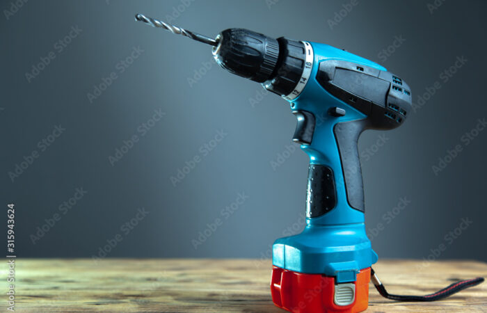 electric drill on a wooden table with dark background