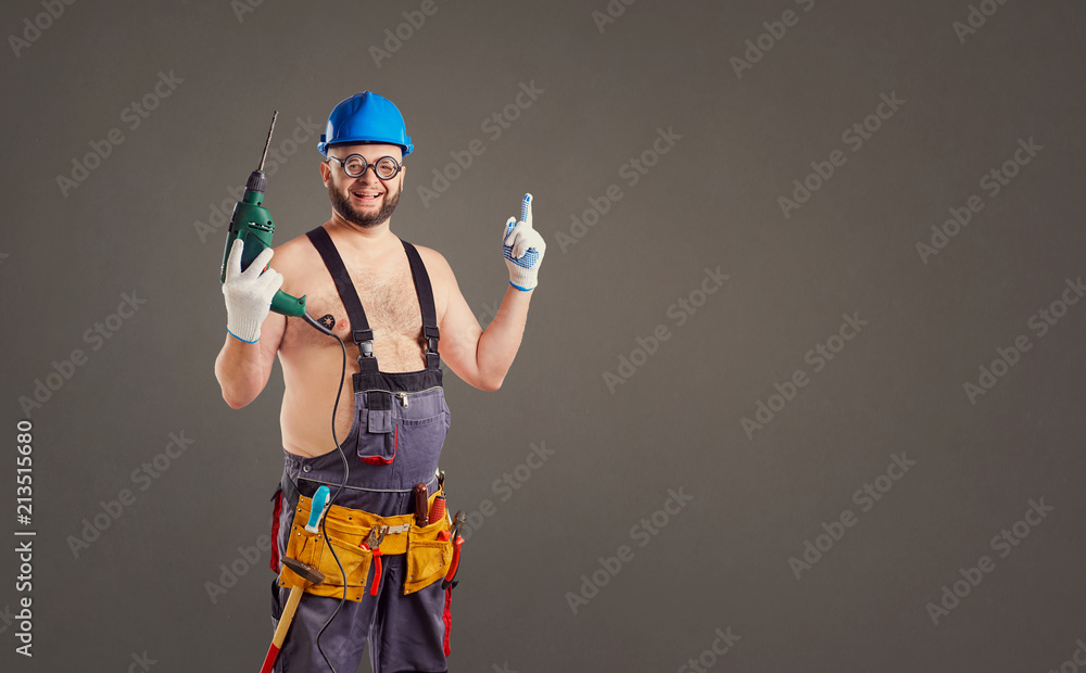 The fat funny man builder with a drill on a background for text.